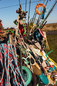 Clothes hanging on rope on field against sky