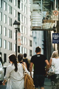 Rear view of people walking in city