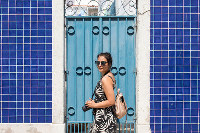 Portrait of woman standing against closed door