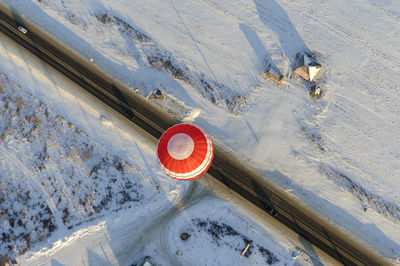 Hot air balloon flying over snow covered field