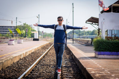 Full length of man standing on railroad tracks against sky
