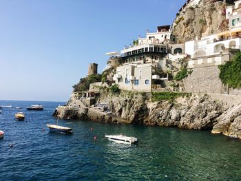 Scenic view of sea by buildings against clear sky