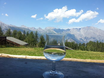 Close-up of wineglass against mountains