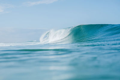 Scenic view of waves in sea against sky