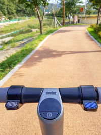 Close-up of bicycle by road against trees in city