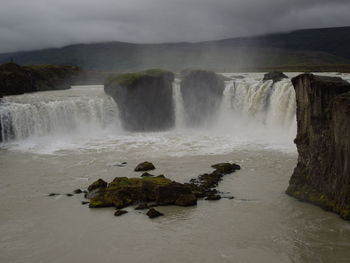 Scenic view of waterfall against sky