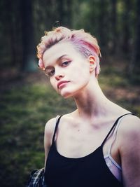 Portrait of beautiful young woman lying on land