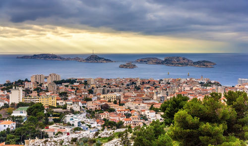 High angle view of townscape by sea against sky