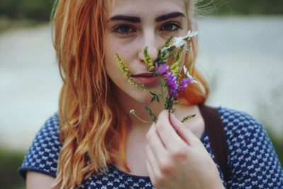 Portrait of beautiful young woman holding flower