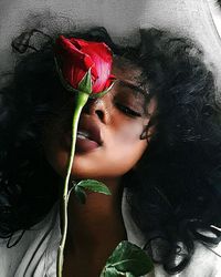 Woman looking at red flower