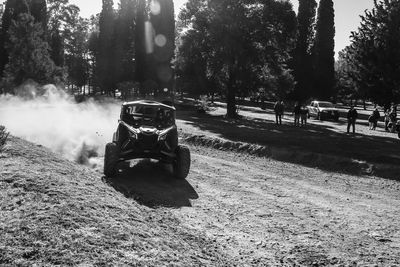 Car on road amidst field in city