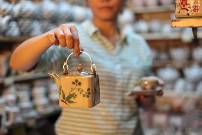 Woman holding teapot in store