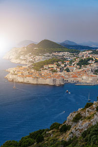 High angle view of townscape by sea against sky