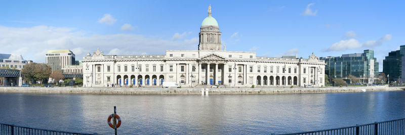 Buildings in city against cloudy sky