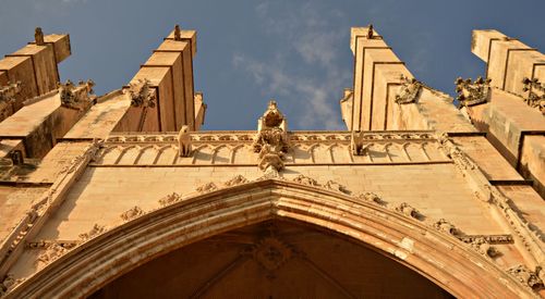 Low angle view of statues on building against sky