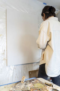 Side view of young woman standing at home