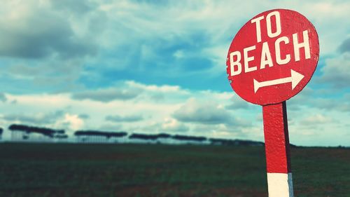 Close-up of road sign against sky