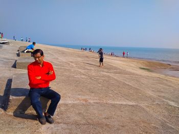 People on beach against clear sky