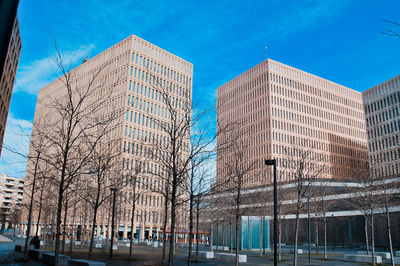 Low angle view of modern buildings against blue sky