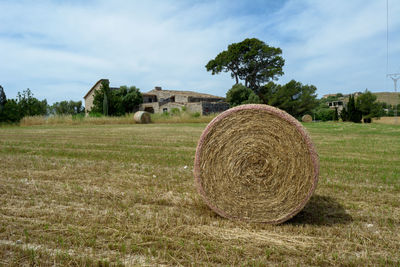 Hay bales on field against sky