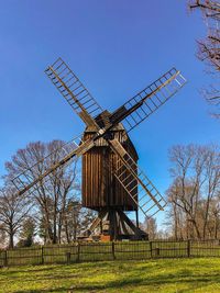 Traditional windmill on field against sky