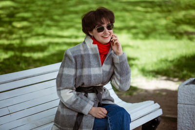 Young woman smiling while sitting on bench