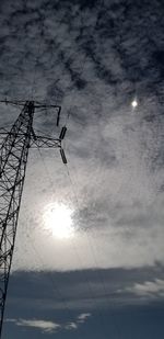 Low angle view of silhouette electricity pylon against sky