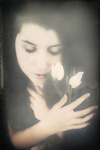 Portrait of beautiful woman holding white flowering plant