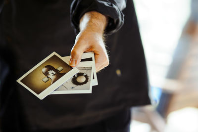 Midsection of man holding instant print transfers