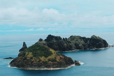 Rock formation by sea against sky