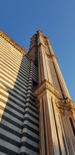 Low angle view of historical building against clear blue sky