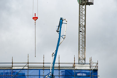 Low angle view of crane against sky