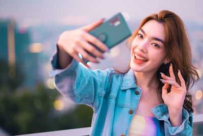 Portrait of young woman using mobile phone