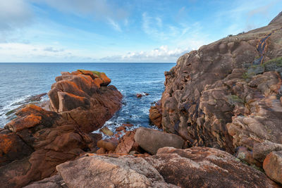 Rock formation on beach against sky