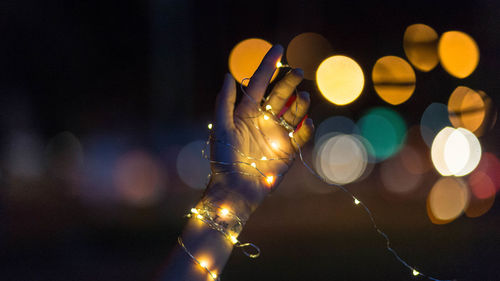 Cropped image of hand holding lighting equipments