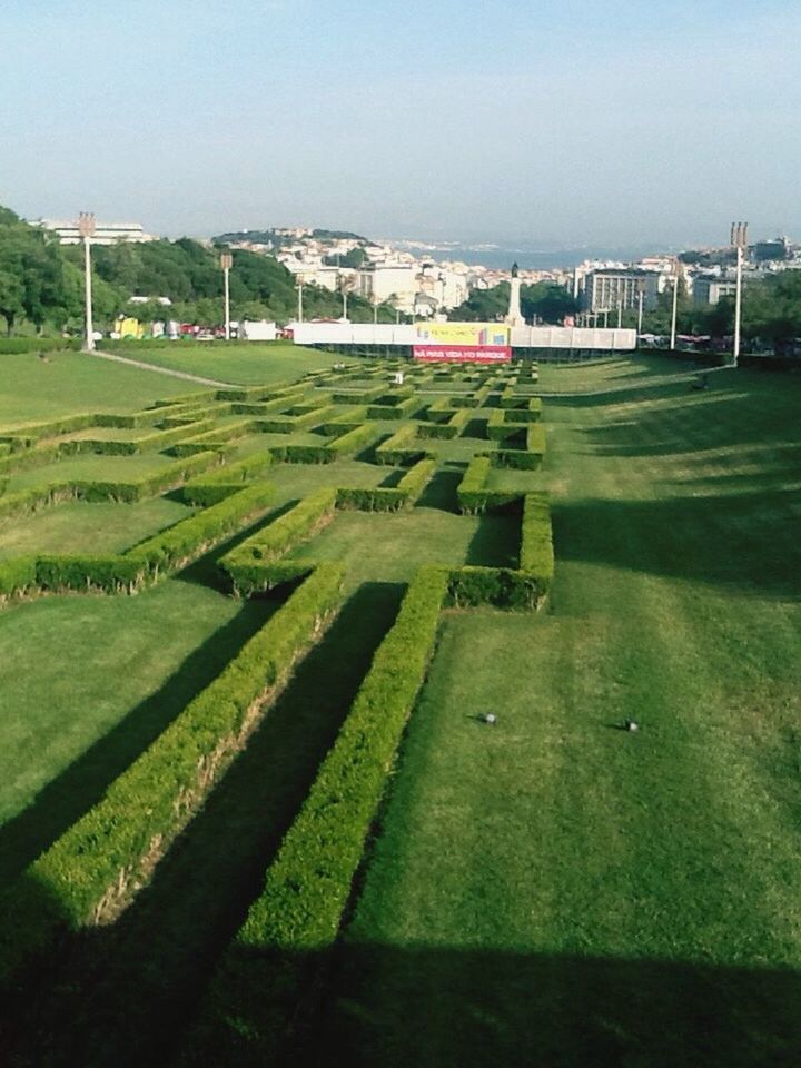 grass, architecture, built structure, building exterior, green color, grassy, field, clear sky, lawn, day, sky, house, outdoors, landscape, sport, grassland, copy space, incidental people, road, no people