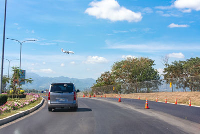 Cars on street against sky