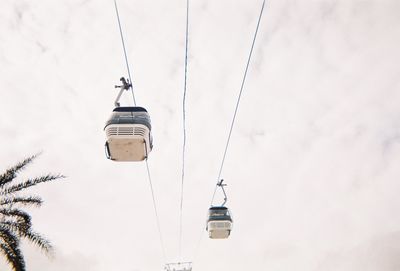 Low angle view of overhead cable car against sky