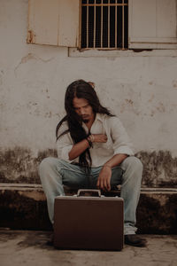 Young man using mobile phone while sitting at home