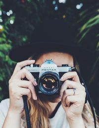 Close-up portrait of hand holding camera