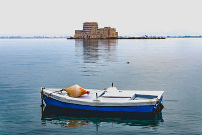 Boat moored in lake against sky