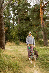 Rear view of man with dog on field