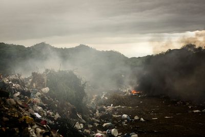 Burning garbage emitting smoke at junkyard