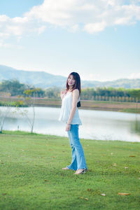 Side view of woman standing on field against sky