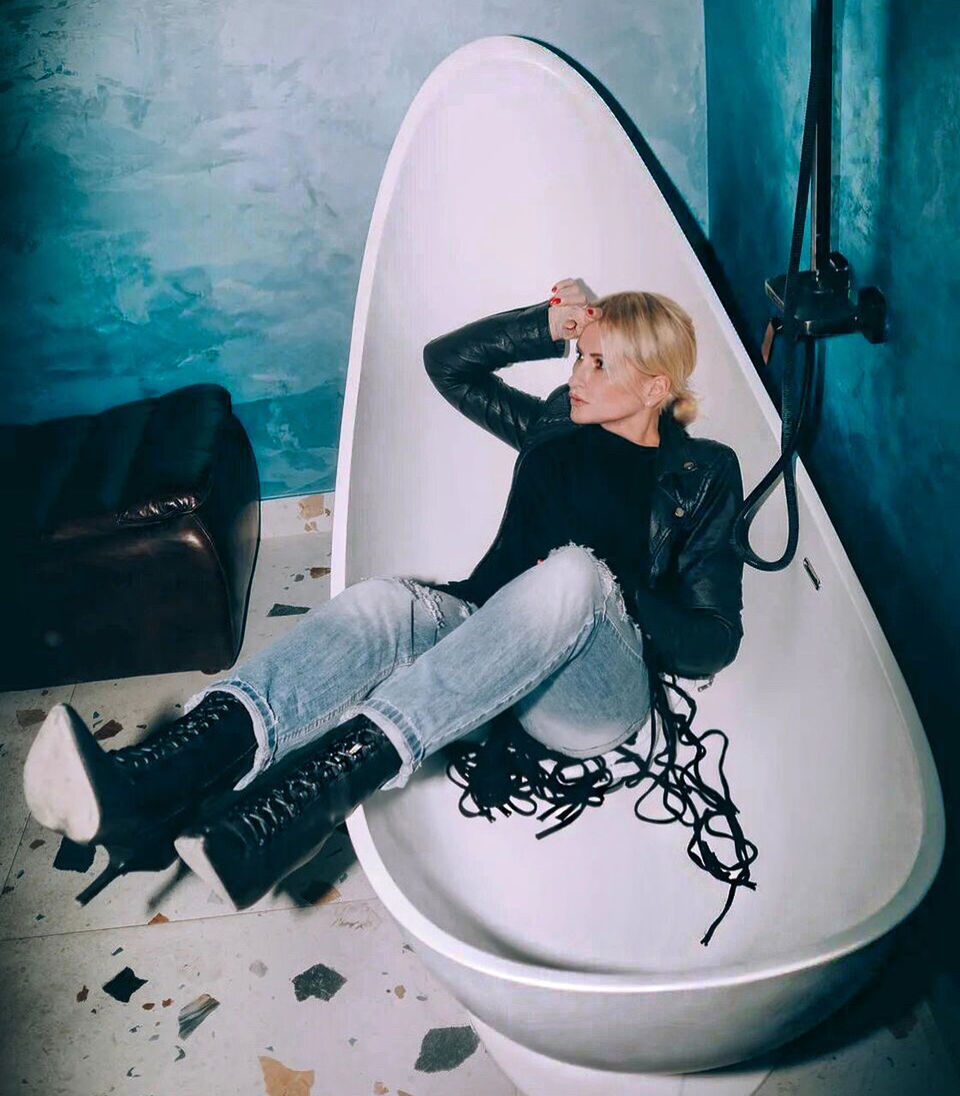 YOUNG WOMAN SITTING ON CHAIR IN ROOM