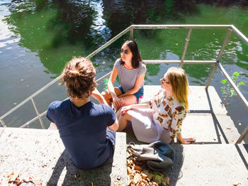 High angle view of friends sitting in water