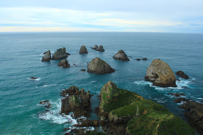 Scenic view of rocks in sea against sky