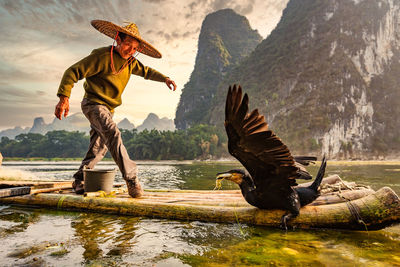 Full length of a bird flying over lake
