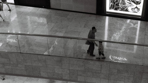 High angle view of people walking on glass window