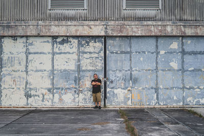 Man standing on footpath by street